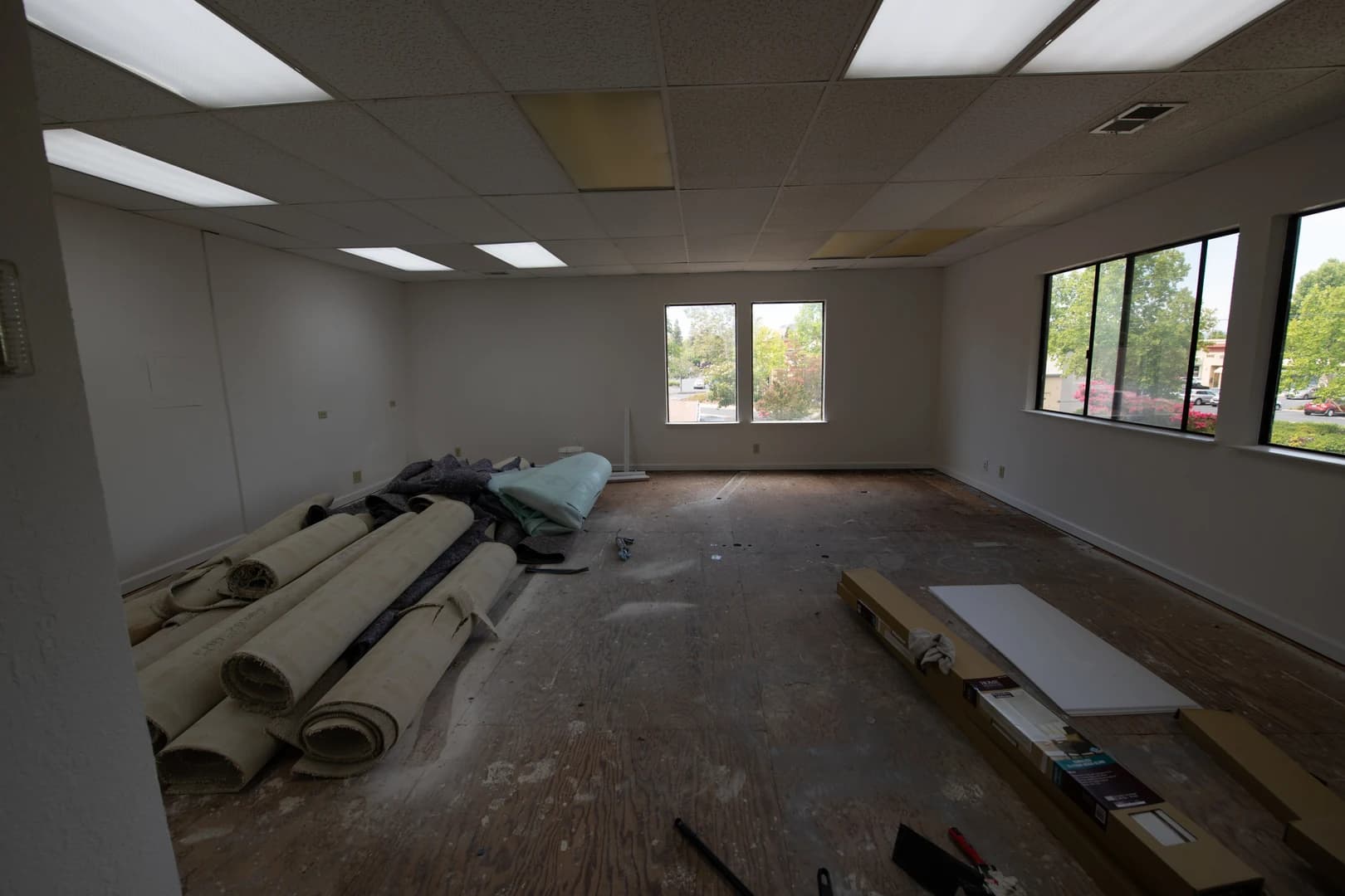 Empty commercial space in Concord, California — rolled carpet, bare concrete floor, the raw starting point before Casey Quist's studio build