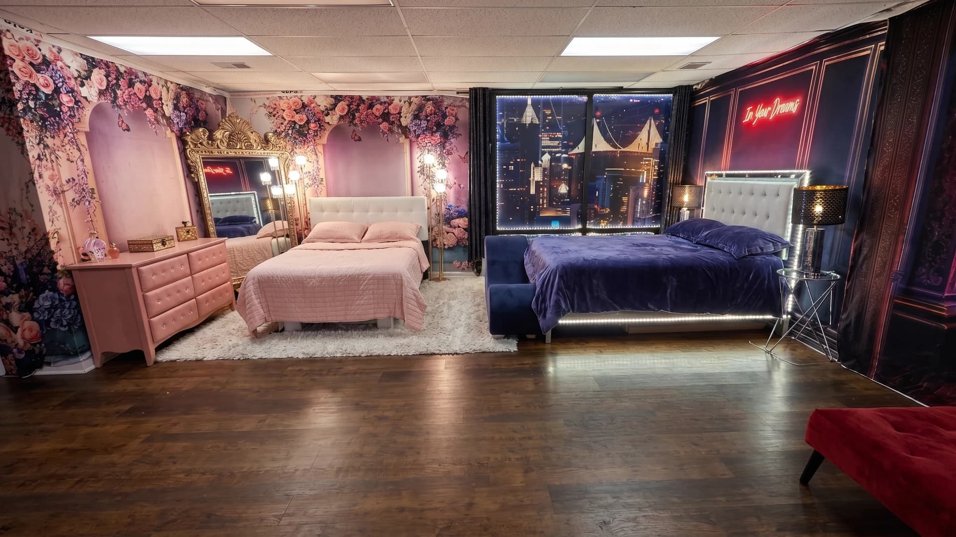 Wide view of Casey Quist's studio showing the pink floral set and the navy cityscape set side by side on dark hardwood floors